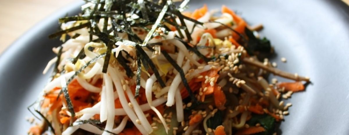 Vegetable noodles topped with sesame and seaweed